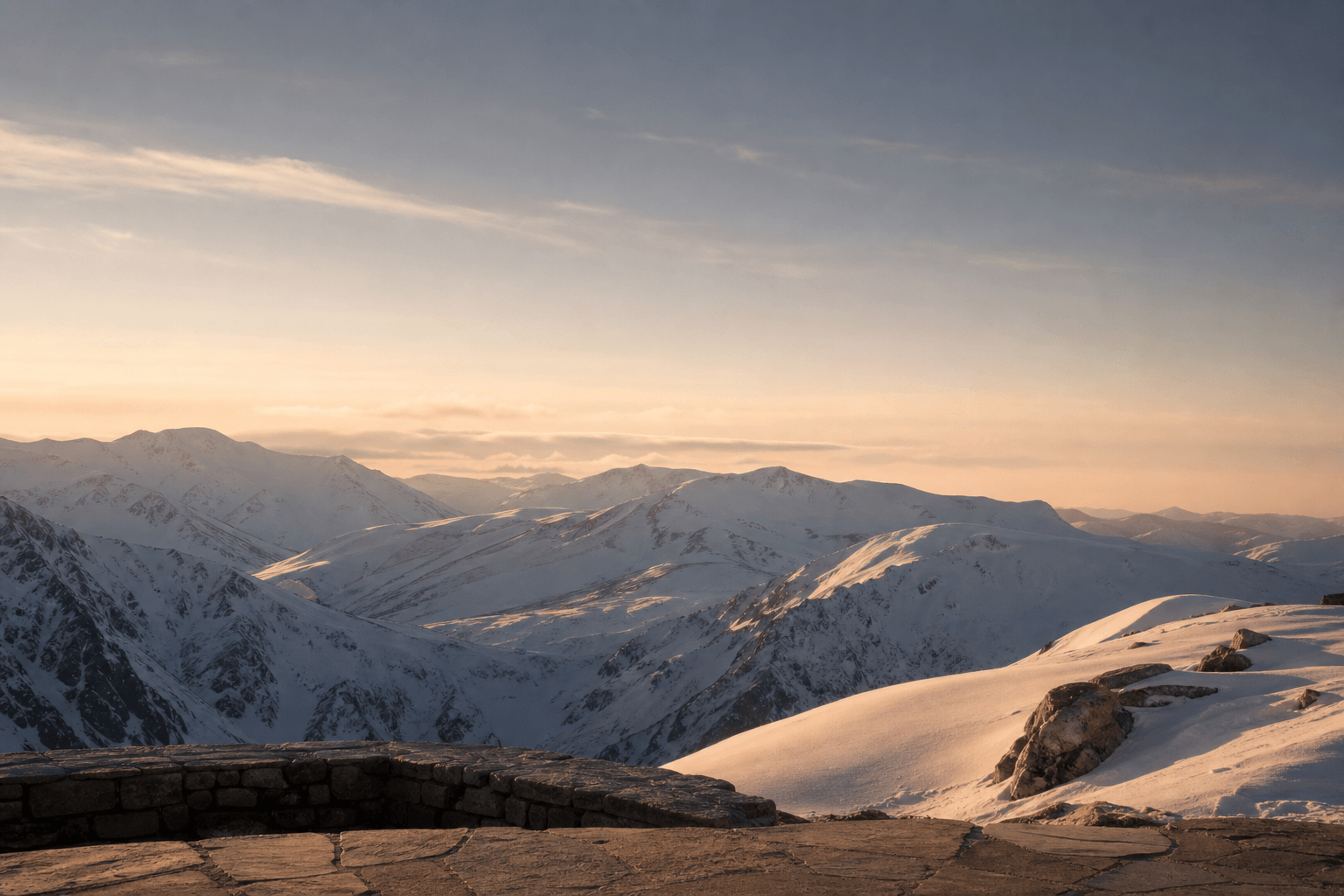 Snow-covered alpine resort mountains at sunset